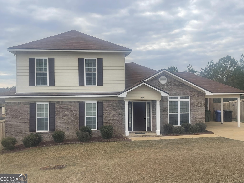 front of property with a carport and a front yard