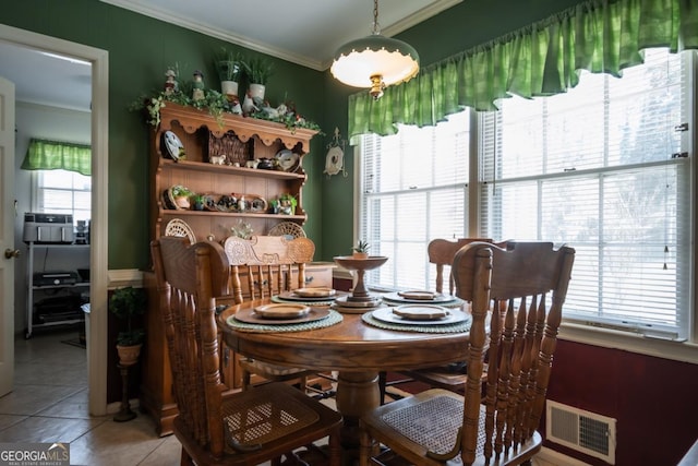 dining room featuring light tile patterned floors, ornamental molding, and visible vents