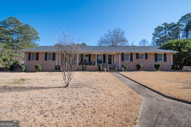 ranch-style house featuring a porch and a front yard