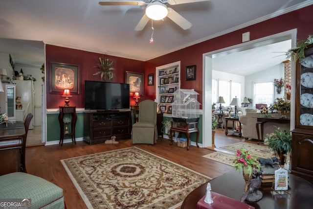 living room with wood finished floors, ornamental molding, and ceiling fan