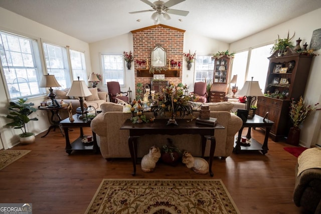 living room featuring ceiling fan, wood finished floors, a brick fireplace, and vaulted ceiling