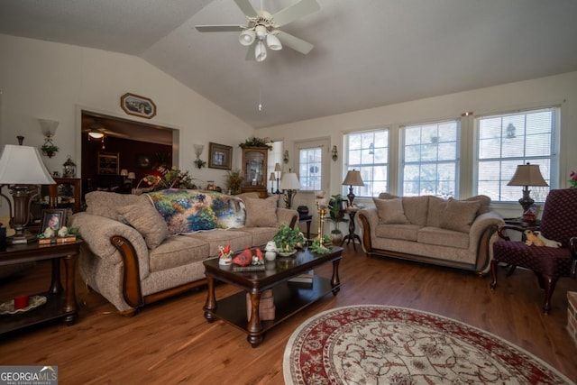 living room featuring light wood finished floors, a ceiling fan, and lofted ceiling