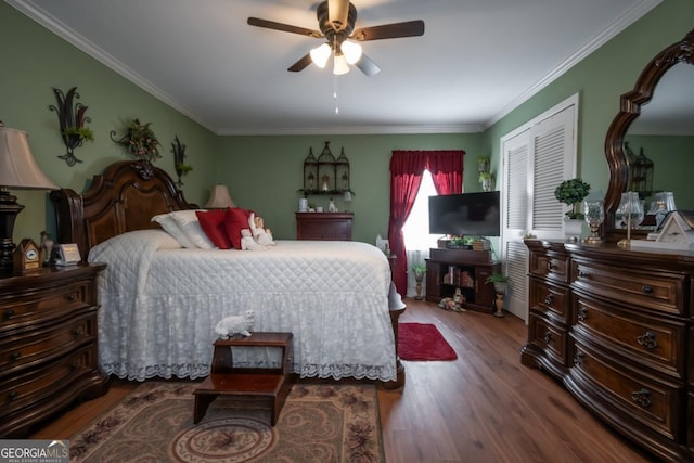 bedroom with hardwood / wood-style flooring, ceiling fan, crown molding, and a closet