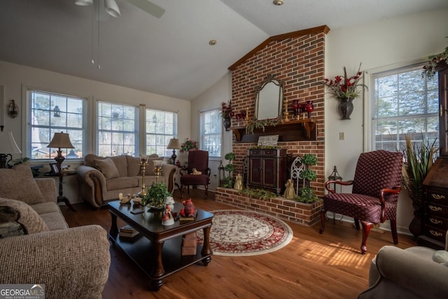 living room with a fireplace, ceiling fan, vaulted ceiling, and wood finished floors
