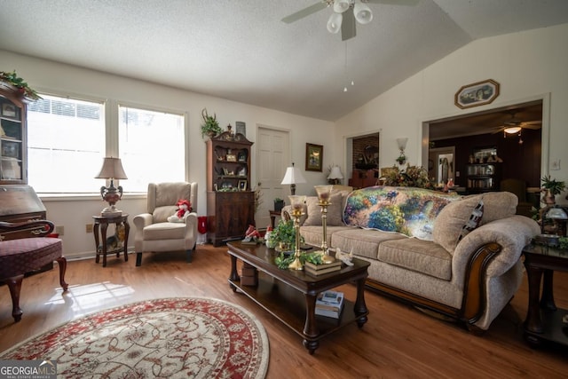 living room with a ceiling fan, wood finished floors, and vaulted ceiling