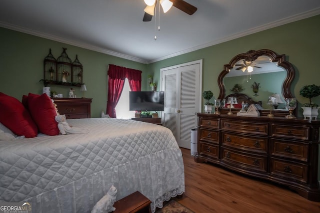 bedroom featuring hardwood / wood-style flooring, ornamental molding, ceiling fan, and a closet