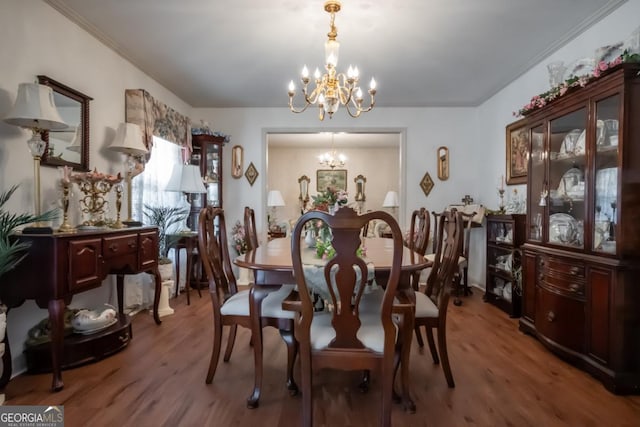 dining area featuring hardwood / wood-style flooring, ornamental molding, and a chandelier