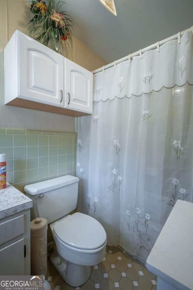 bathroom with a shower with shower curtain, toilet, and vanity