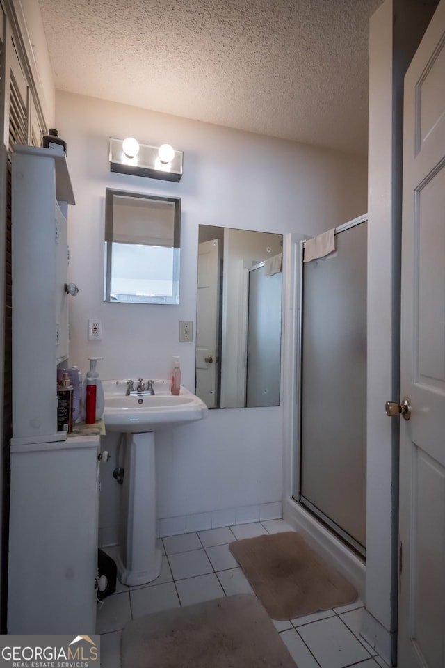 bathroom with sink, tile patterned floors, a textured ceiling, and walk in shower