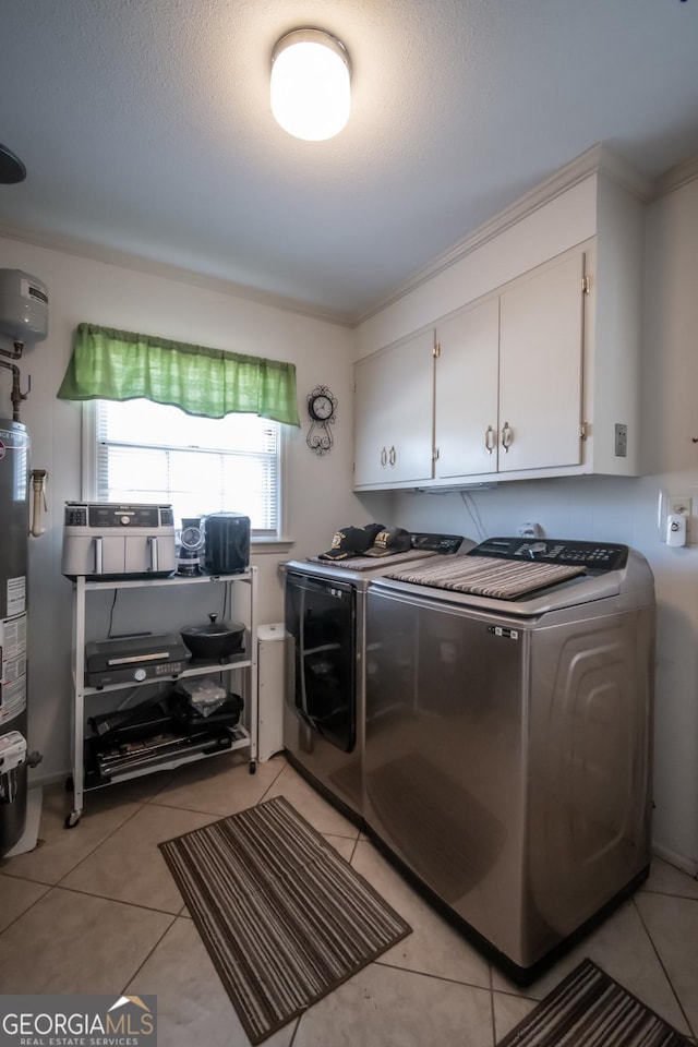 clothes washing area with cabinet space, gas water heater, light tile patterned flooring, and separate washer and dryer