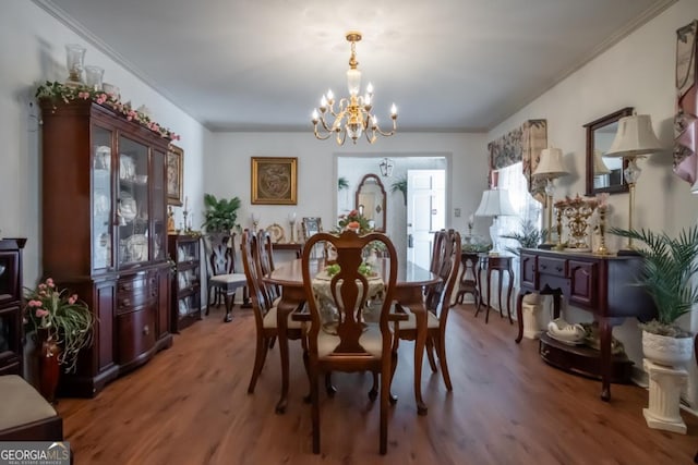 dining space featuring hardwood / wood-style flooring, crown molding, and a chandelier