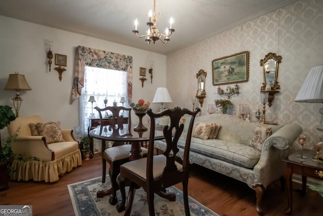 sitting room featuring wallpapered walls, wood finished floors, an inviting chandelier, and crown molding