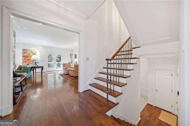 staircase featuring french doors, ornamental molding, and hardwood / wood-style floors