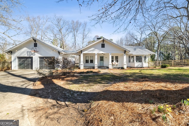 view of front of house with covered porch, a garage, and a front lawn