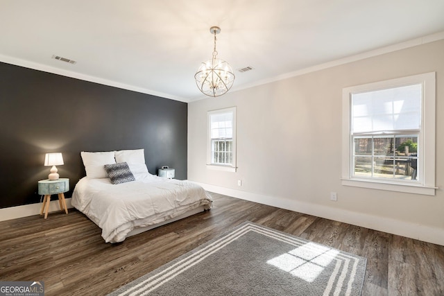 bedroom with a notable chandelier, dark wood-type flooring, and ornamental molding