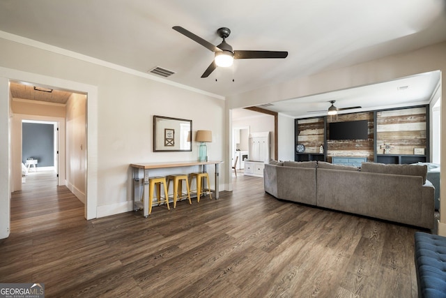 living room with ceiling fan, ornamental molding, and dark hardwood / wood-style flooring