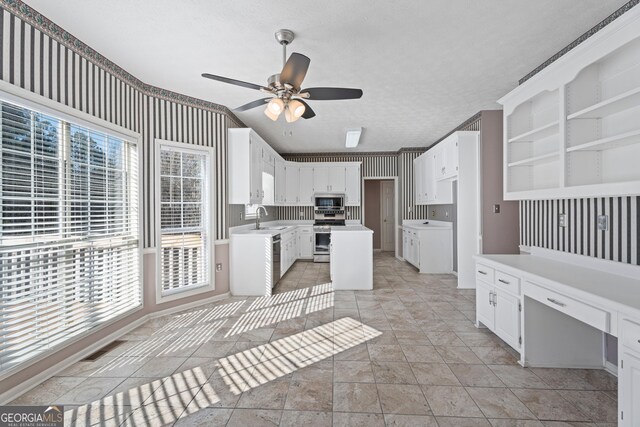 kitchen featuring sink, plenty of natural light, stainless steel appliances, and white cabinets