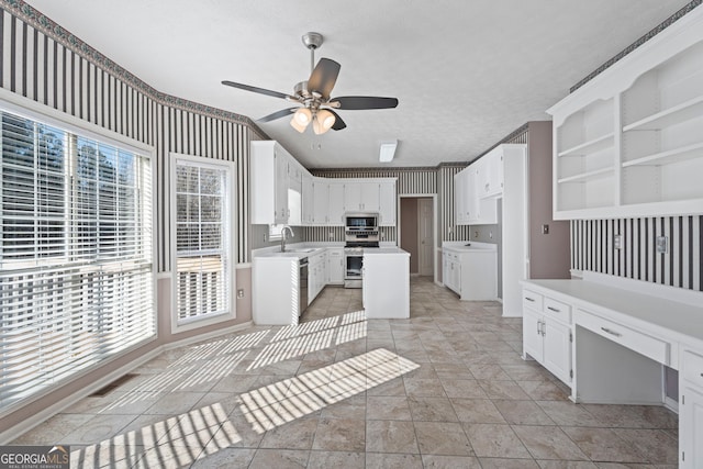 123 Stratmore Pl, Stockbridge, GA 30281 - kitchen with stainless steel appliances, ceiling fan, white cabinets, light countertops, and built in desk