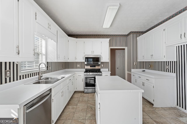 123 Stratmore Pl, Stockbridge, GA 30281 - kitchen featuring wallpapered walls, appliances with stainless steel finishes, a center island, white cabinets, and light countertops