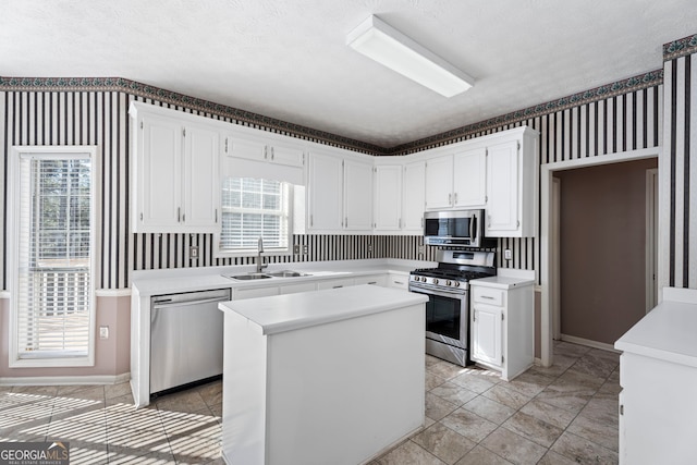 kitchen with sink, white cabinetry, a center island, plenty of natural light, and stainless steel appliances