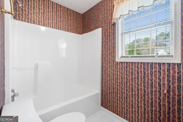 bathroom featuring tile patterned flooring, toilet, and a textured ceiling