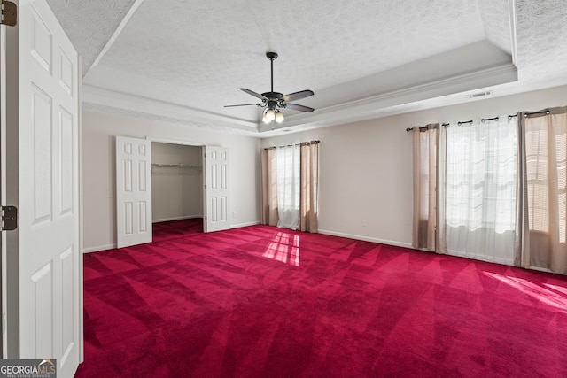 123 Stratmore Pl, Stockbridge, GA 30281 - unfurnished bedroom with a raised ceiling, a textured ceiling, carpet flooring, a ceiling fan, and a closet