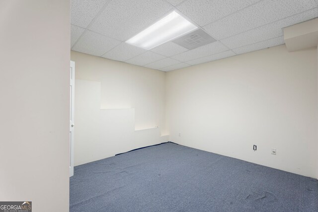 carpeted empty room with a paneled ceiling