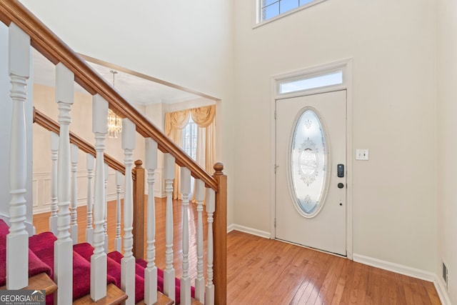 entryway featuring a high ceiling, a healthy amount of sunlight, and light hardwood / wood-style flooring