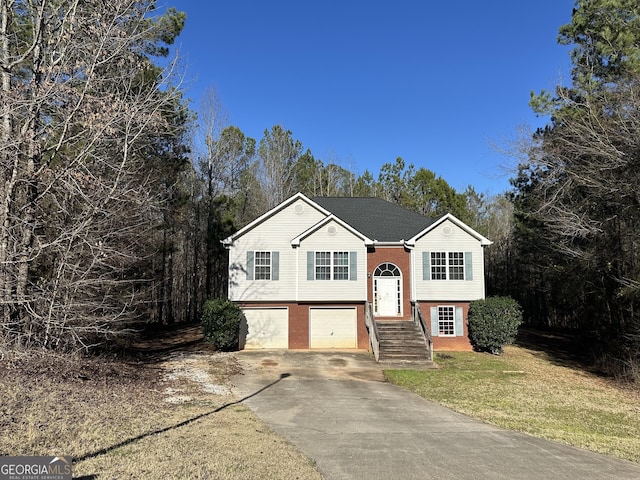 split foyer home featuring a garage and a front yard