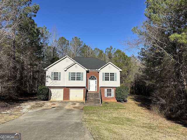 split foyer home featuring a garage and a front yard