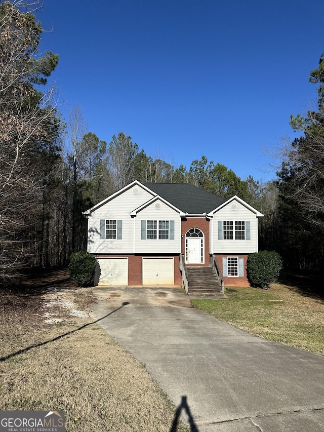 split foyer home with a garage and a front yard