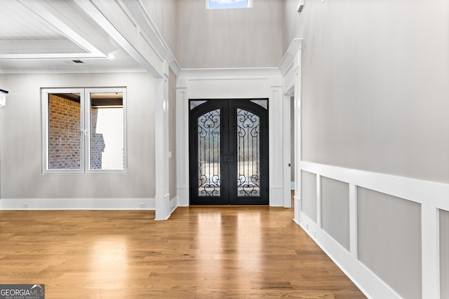 foyer entrance with french doors, plenty of natural light, and wood finished floors