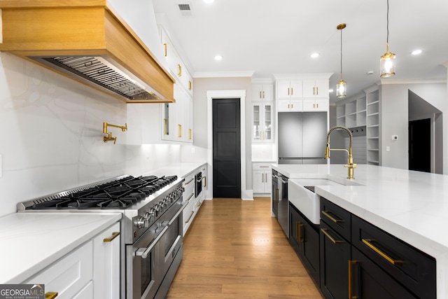 kitchen with range with two ovens, glass insert cabinets, light stone countertops, light wood-style floors, and white cabinetry