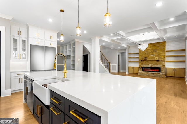 kitchen with light wood finished floors, white cabinetry, and coffered ceiling