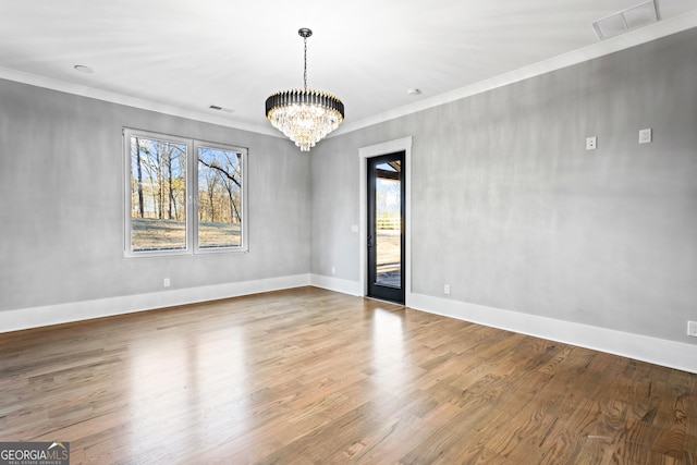 interior space with ornamental molding, a healthy amount of sunlight, and wood finished floors