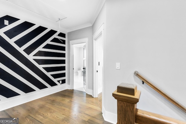 entryway with ornamental molding and wood finished floors