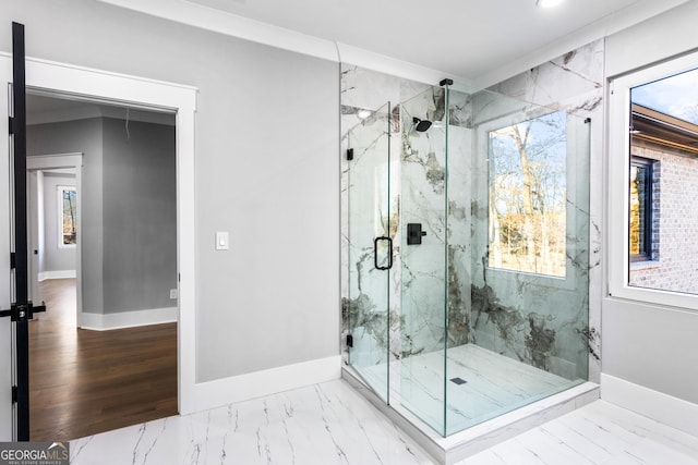 full bath featuring marble finish floor, a marble finish shower, and baseboards