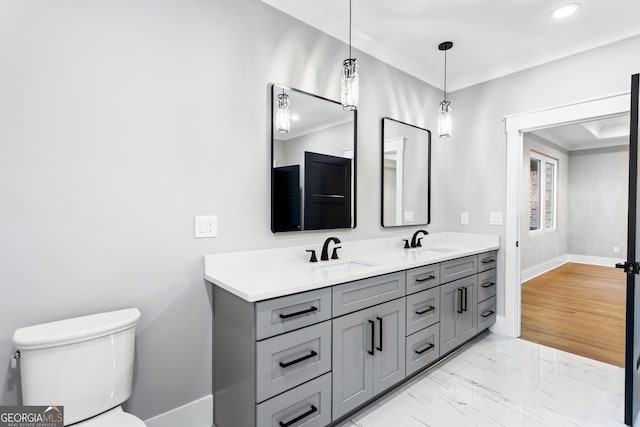 bathroom featuring marble finish floor, a sink, toilet, and crown molding