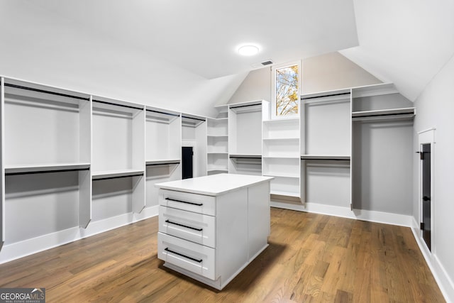 walk in closet with vaulted ceiling and wood finished floors