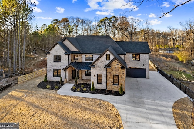 modern farmhouse style home with metal roof, an attached garage, fence, decorative driveway, and a standing seam roof