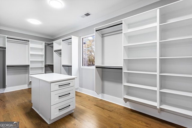 spacious closet featuring dark wood-style flooring and visible vents