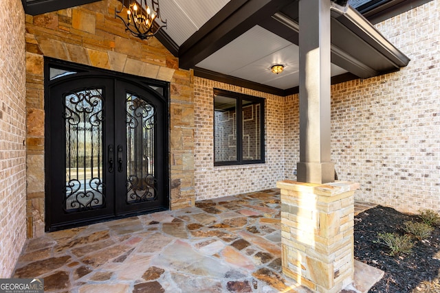 property entrance featuring brick siding and french doors