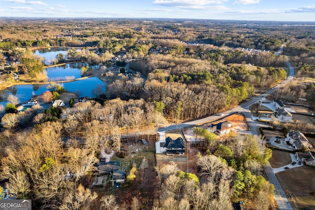 aerial view featuring a water view and a wooded view