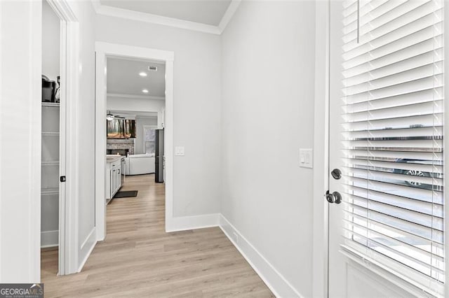 interior space with light wood-type flooring and crown molding