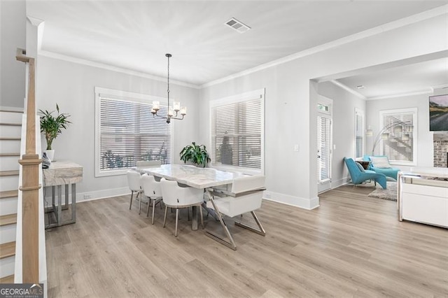 dining space featuring light hardwood / wood-style floors, a chandelier, and crown molding