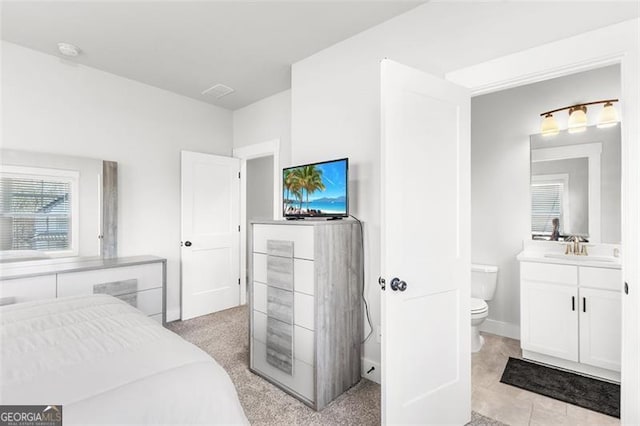 bedroom featuring sink and ensuite bath