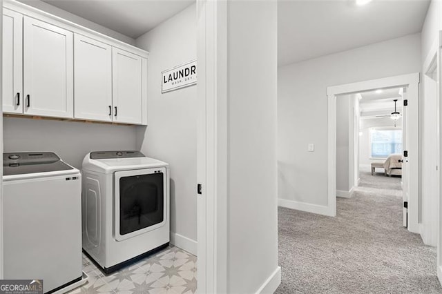 laundry area featuring light carpet, cabinets, and washer and clothes dryer