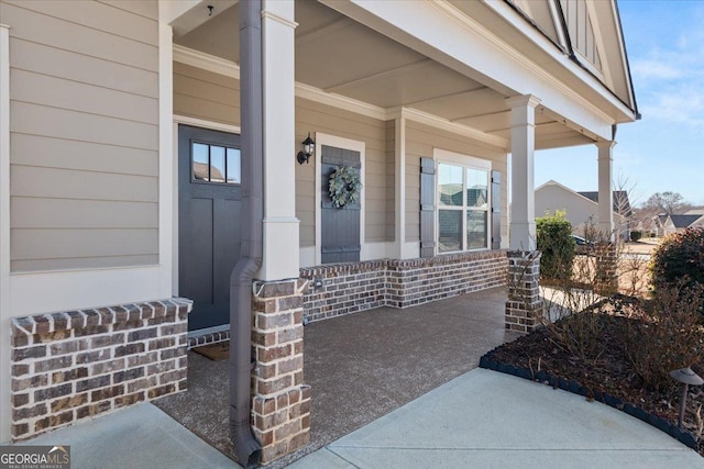 view of exterior entry featuring covered porch