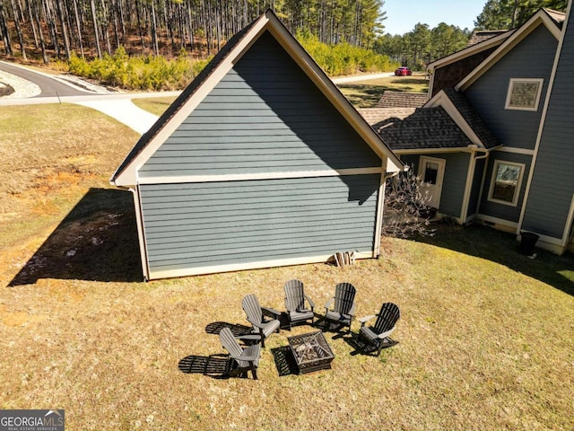 view of property exterior with a yard and an outdoor fire pit