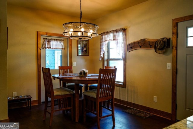 dining space featuring dark hardwood / wood-style floors and an inviting chandelier